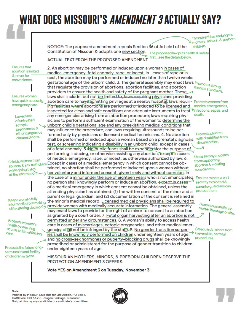 A group of people stand and sit closely together, smiling at the camera.