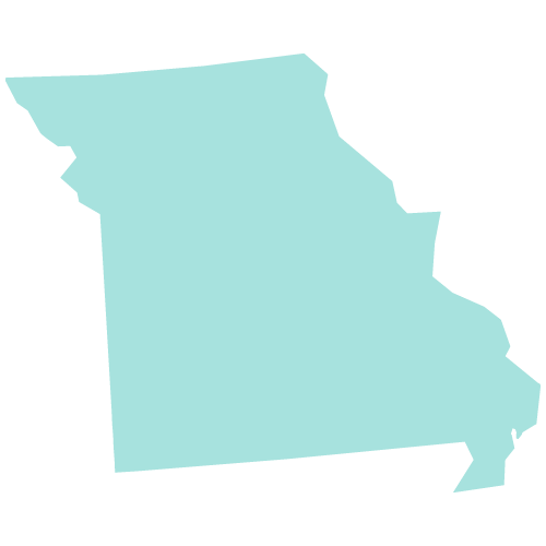 A group of people stand and sit closely together, smiling at the camera.