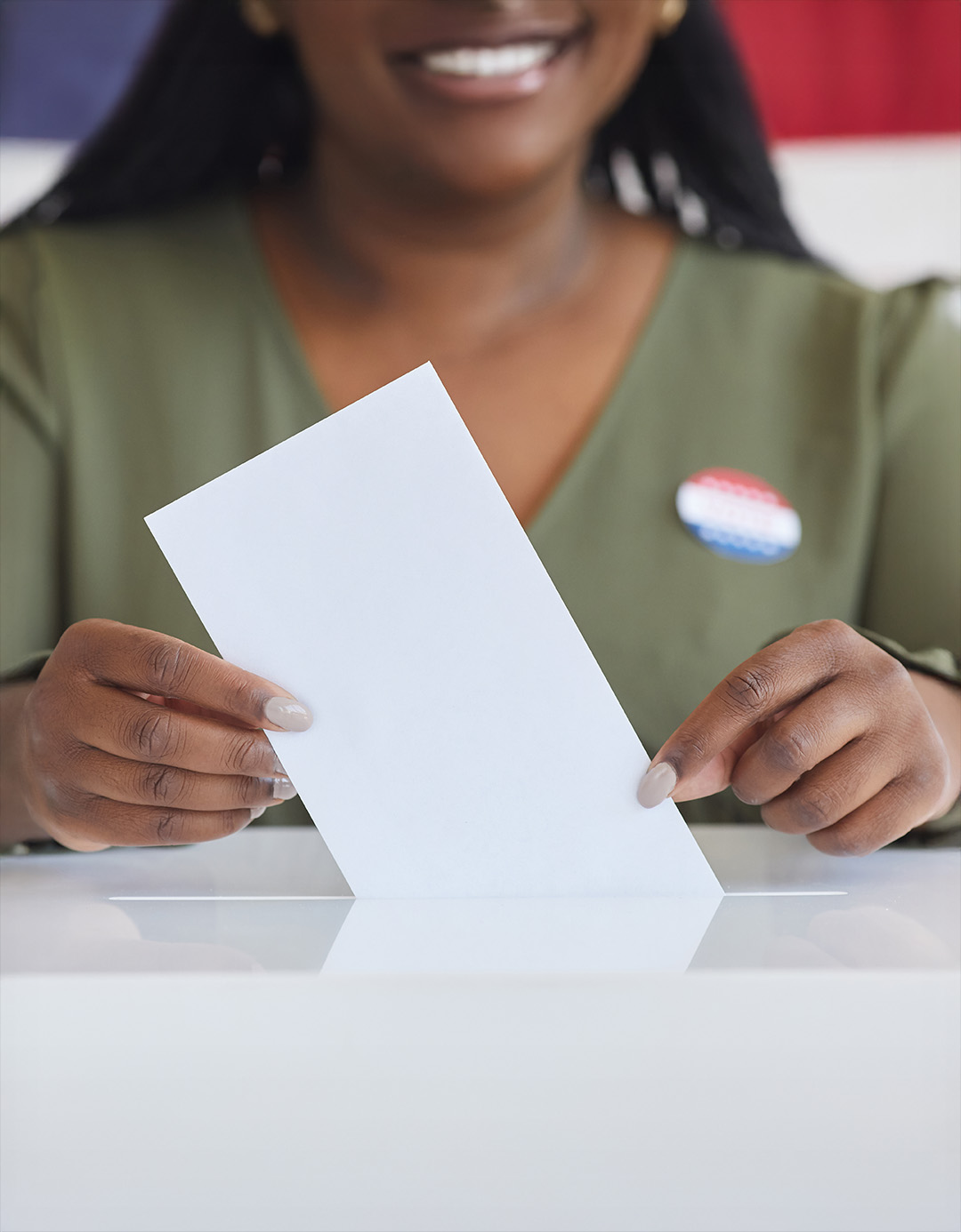 A group of people stand and sit closely together, smiling at the camera.