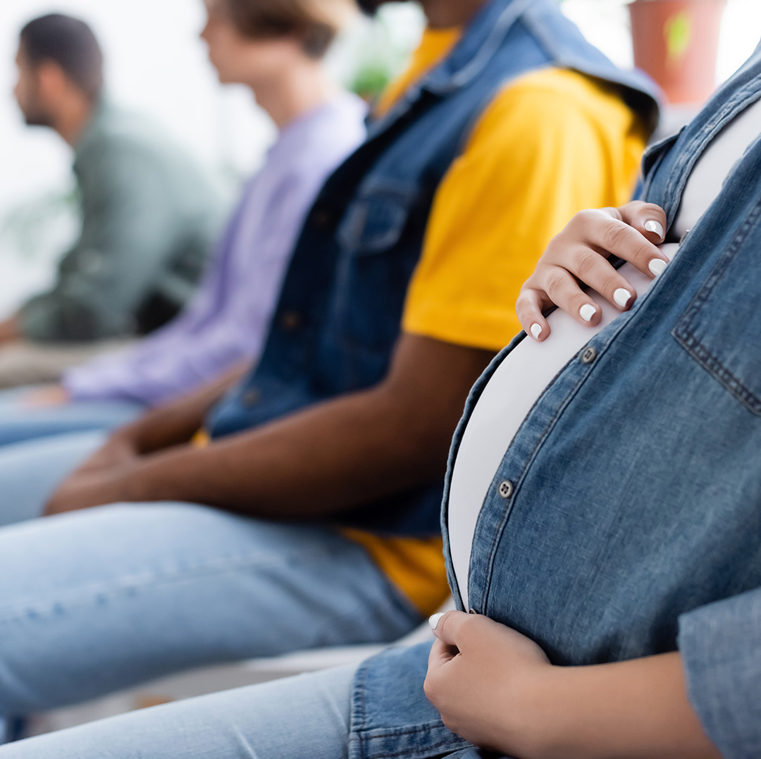 A group of people stand and sit closely together, smiling at the camera.